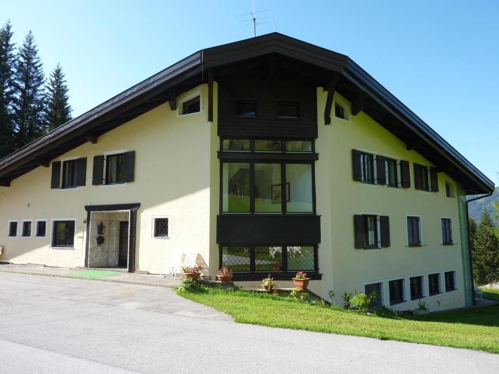 ein großes weißes Gebäude mit schwarzem Dach in der Unterkunft Appartementhaus Hochkönig 1 - Alpenrose in Mühlbach am Hochkönig