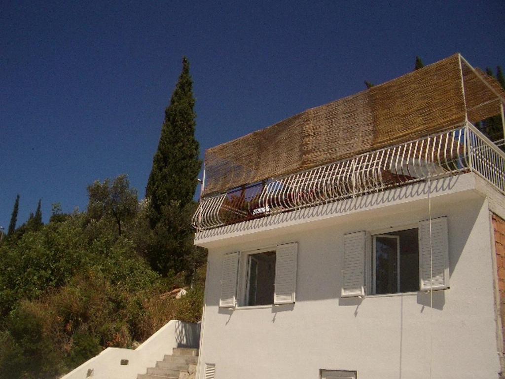 a white building with a balcony on top of it at Apartment Dario in Gruda