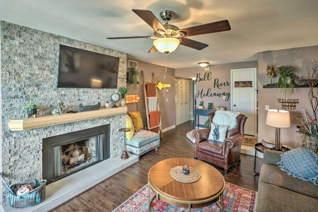 a living room with a fireplace and a ceiling fan at Bullhead City Condo with Direct River Access! in Bullhead City