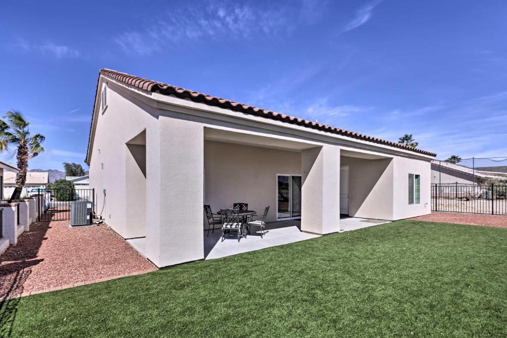 a white house with a large yard at Bright Home with Yard, 4 Mi to Colorado River! in Fort Mohave