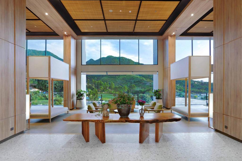 a large living room with a table and large windows at Grand ASTON Puncak Hotel & Resort in Puncak