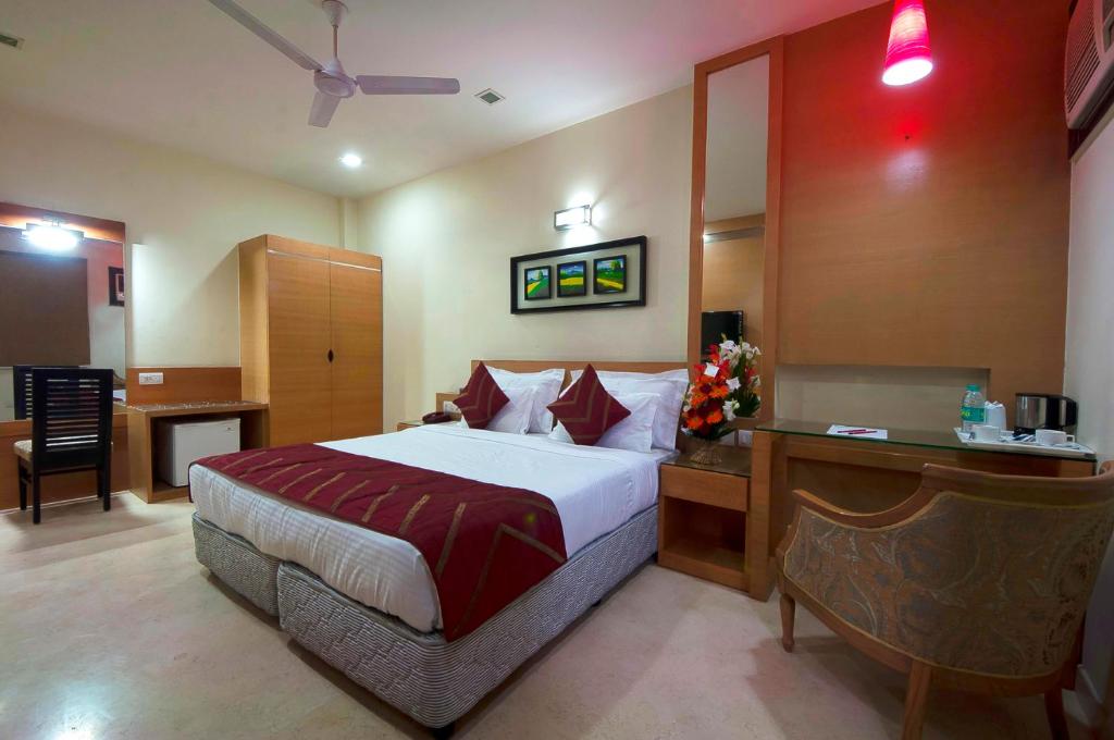 a hotel room with a bed and a desk with a desk at Hotel Metropolitan in New Delhi