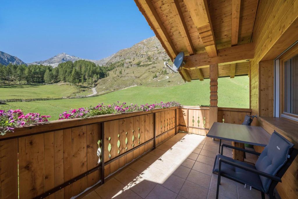 a balcony with a table and chairs and a view at Fewo Sonnenaufgang - Zeppichl in Pfelders