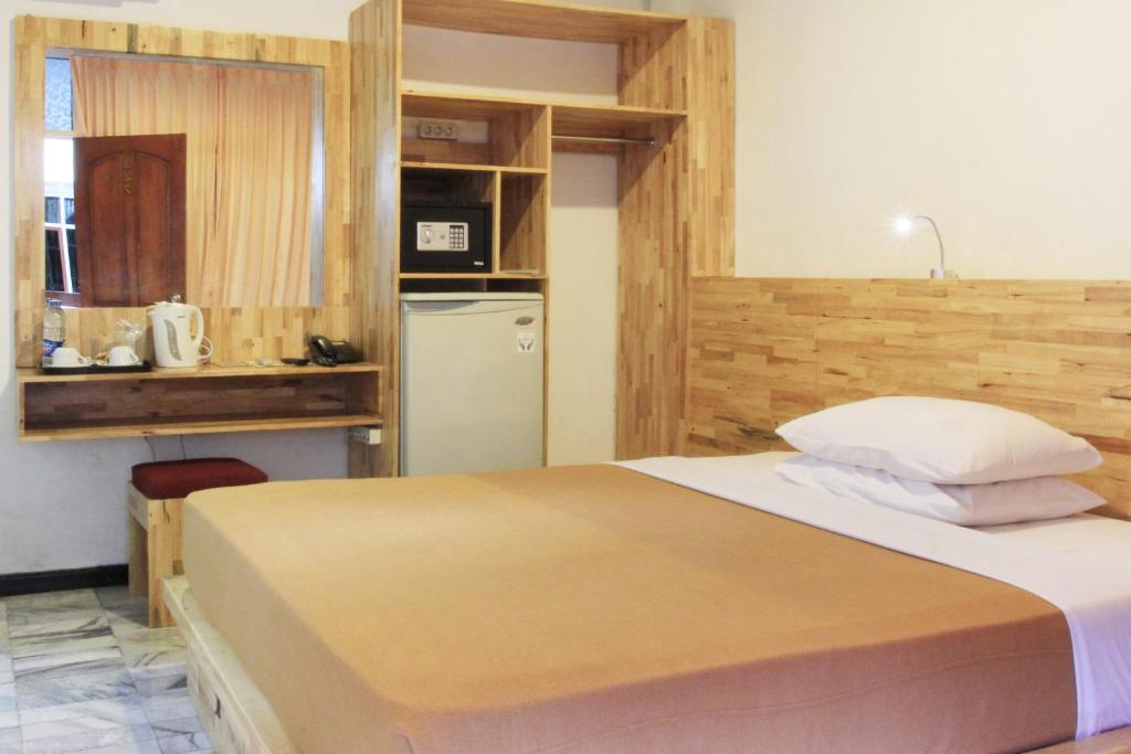 Postel nebo postele na pokoji v ubytování Hotel Karthi Kuta