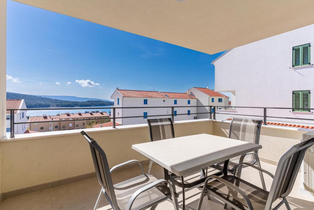 a table and chairs on a balcony with a view at Blue Pearl Apartment in Cres