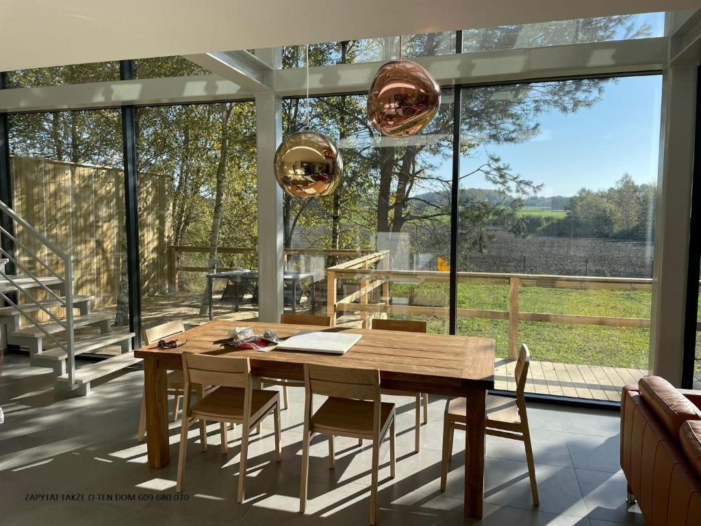 een eetkamer met een tafel en stoelen en een groot raam bij Modern Holiday Home in Kamień with a View and Garden in Kamień