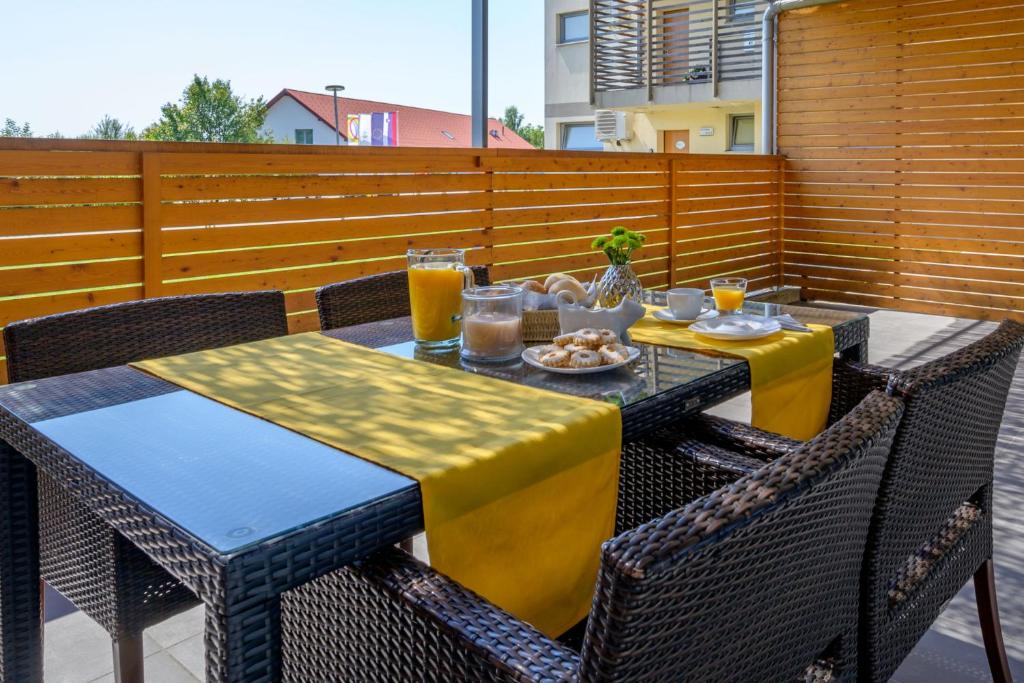 una mesa y sillas con bebidas y comida en un patio en Family apartment Moravske Toplice, en Moravske Toplice