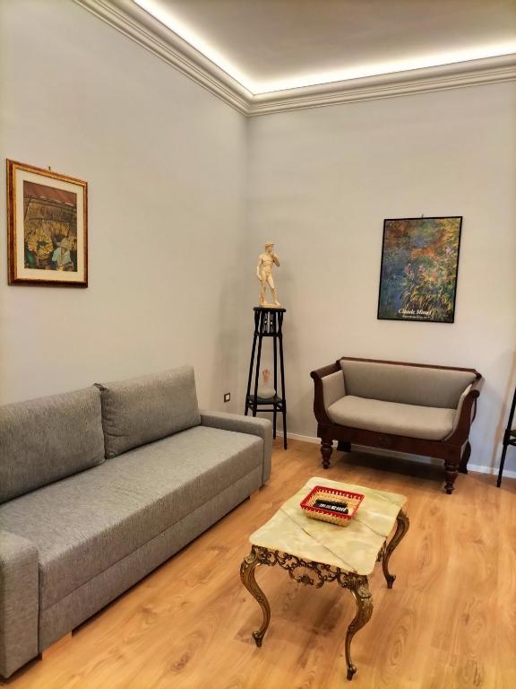 uma sala de estar com um sofá e uma mesa em Start Living House em Taormina