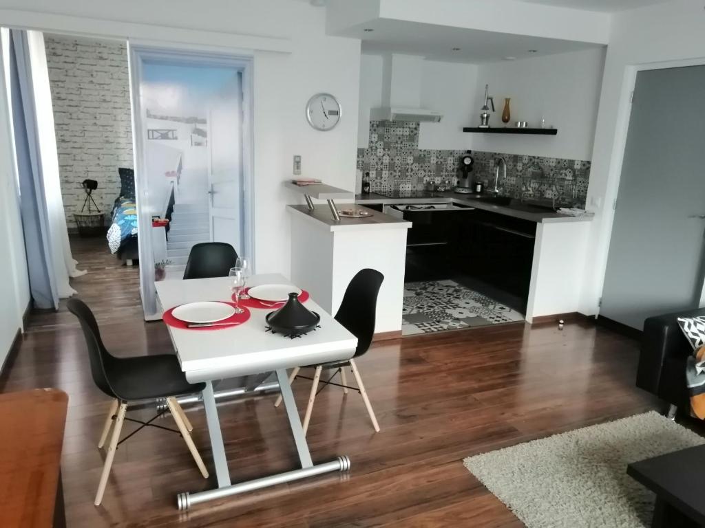 cocina y sala de estar con mesa blanca y sillas en La maison de 6Fran appartement 1 calme et spacieux ambiance familiale, en Valros