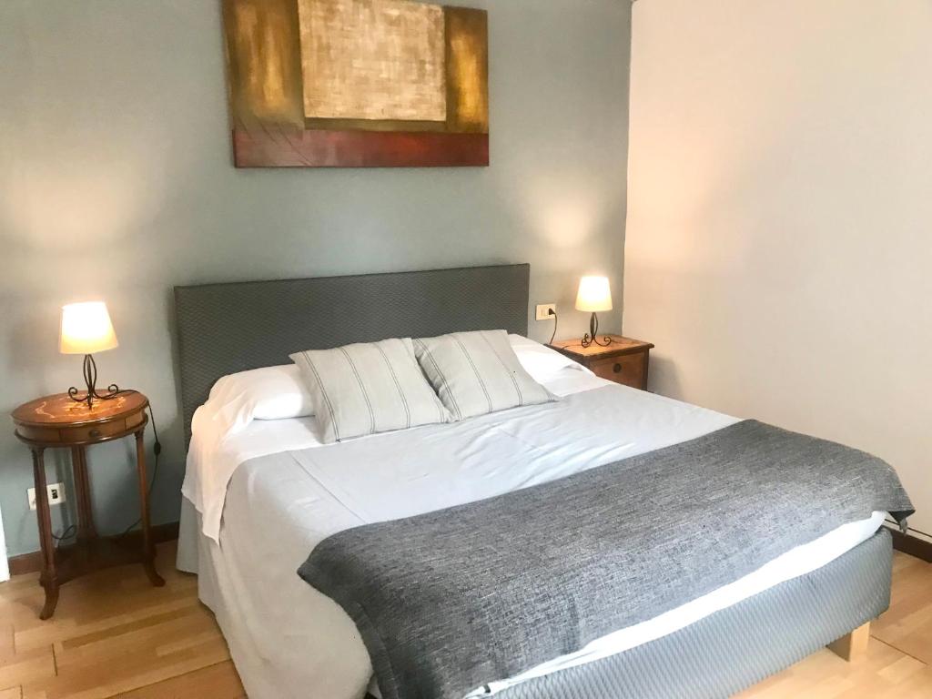 um quarto com uma grande cama branca e 2 candeeiros em Venice and Venice Apartments - private rooms in shared apartment em Veneza