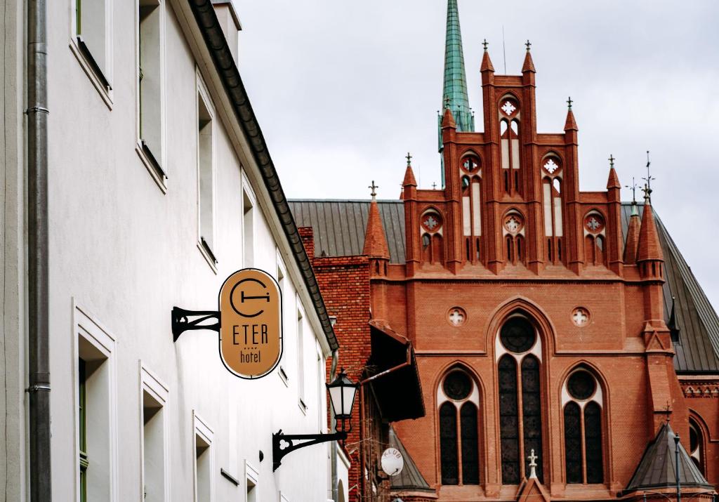 eine Kirche mit einer Uhr an der Seite eines Gebäudes in der Unterkunft Hotel ETER in Toruń