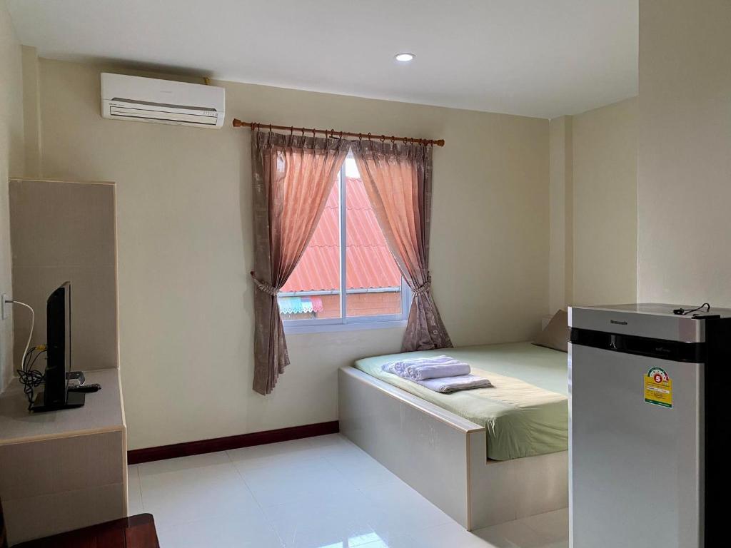 a small room with a bed and a window at Pepa Guest House in Ko Tao