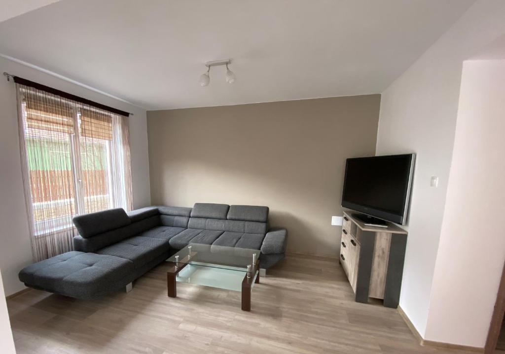 a living room with a couch and a flat screen tv at FENYŐ APARTMAN HOUSE II. in Odorheiu Secuiesc
