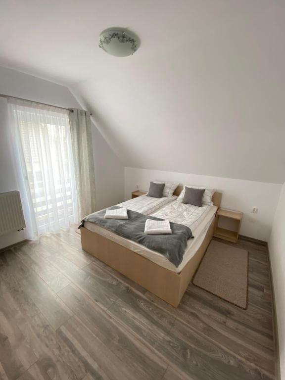 a bedroom with a bed and a large window at FENYŐ APARTMAN HOUSE II. in Odorheiu Secuiesc