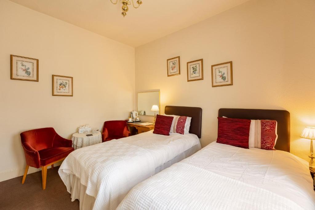 a bedroom with two beds and a desk and a chair at Crossways in Pickering