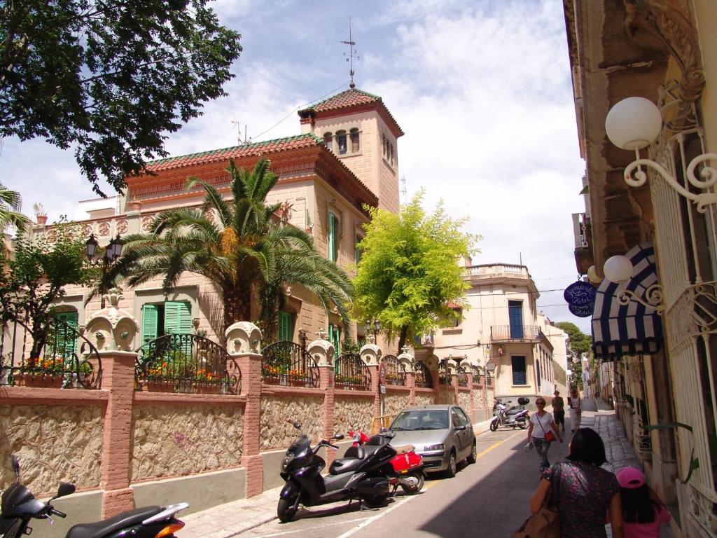 une rue avec des motos garées sur le côté d'un bâtiment dans l'établissement Sitges Royal Rooms, à Sitges