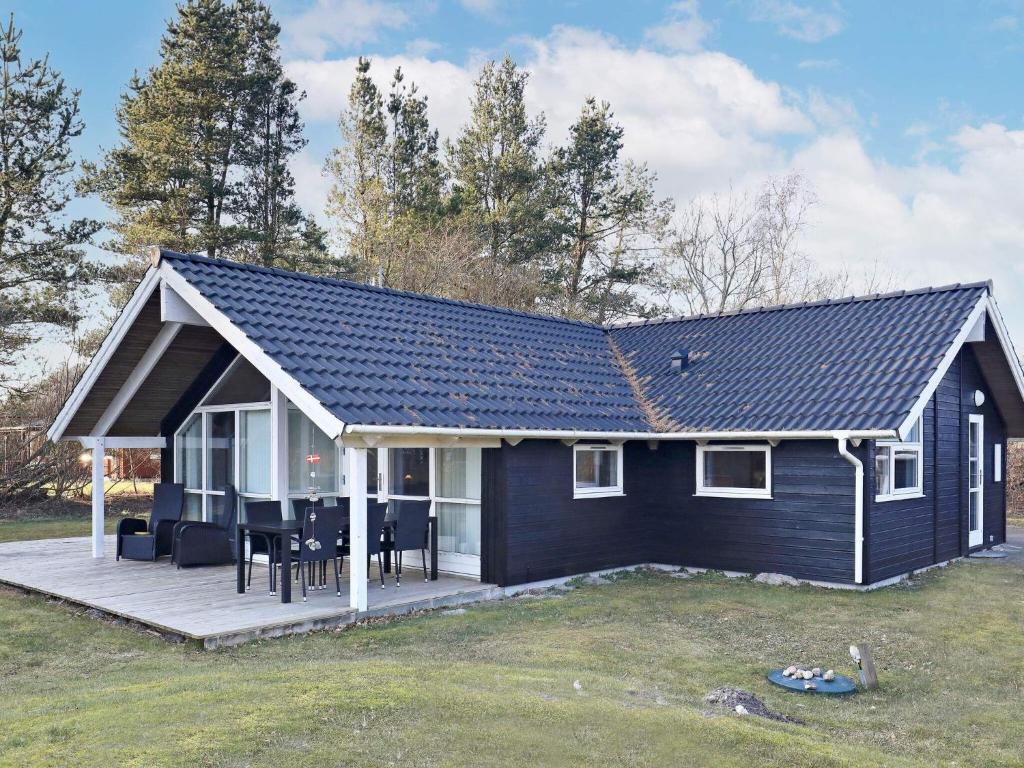 een zwart-wit huis met een terras bij Holiday home Asaa V in Aså