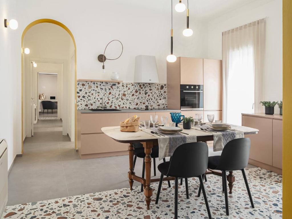 a kitchen with a table and chairs in a room at Living u HomeSuites in Lecce