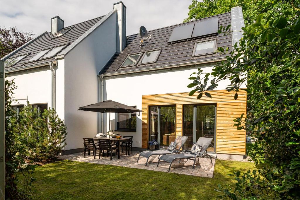 a garden with a patio with a table and chairs at Haus Strandflieder - Domizil am Ostseewald in Zingst