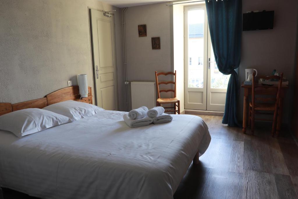a bedroom with a bed with two towels on it at Logis Le Relais de Thézillieu in Thézillieu