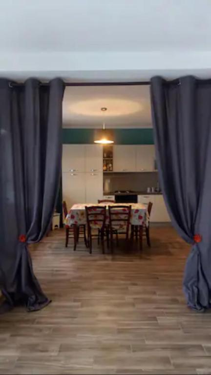 una camera con tende nere e tavolo e sedie di Casa Luisa ad Alba
