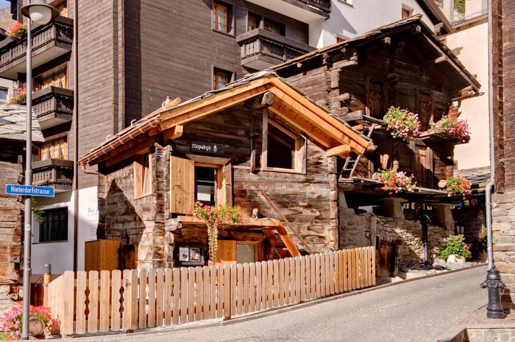 una casa de madera con flores en la parte delantera en Chalet Z'Gogwärgji, en Zermatt