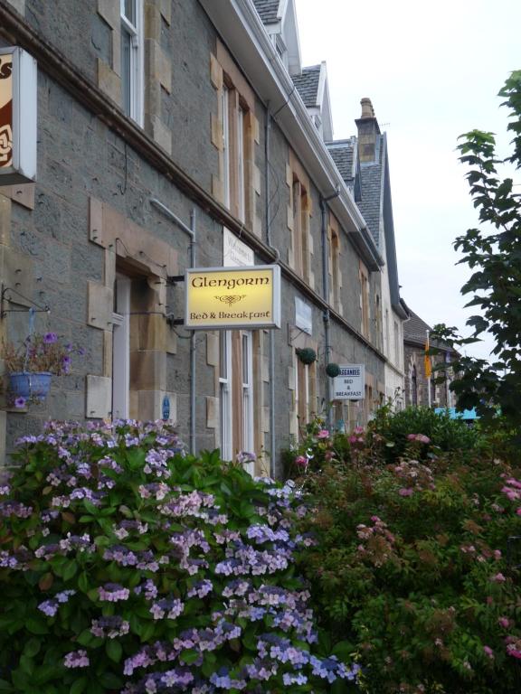 ein Schild an der Seite eines Gebäudes mit Blumen in der Unterkunft Glengorm Guest House in Oban