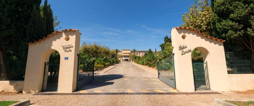 un cancello per una strada con una casa in lontananza di PALAIS LUMIERE : la ''Chambre Blanche'' a La Ciotat