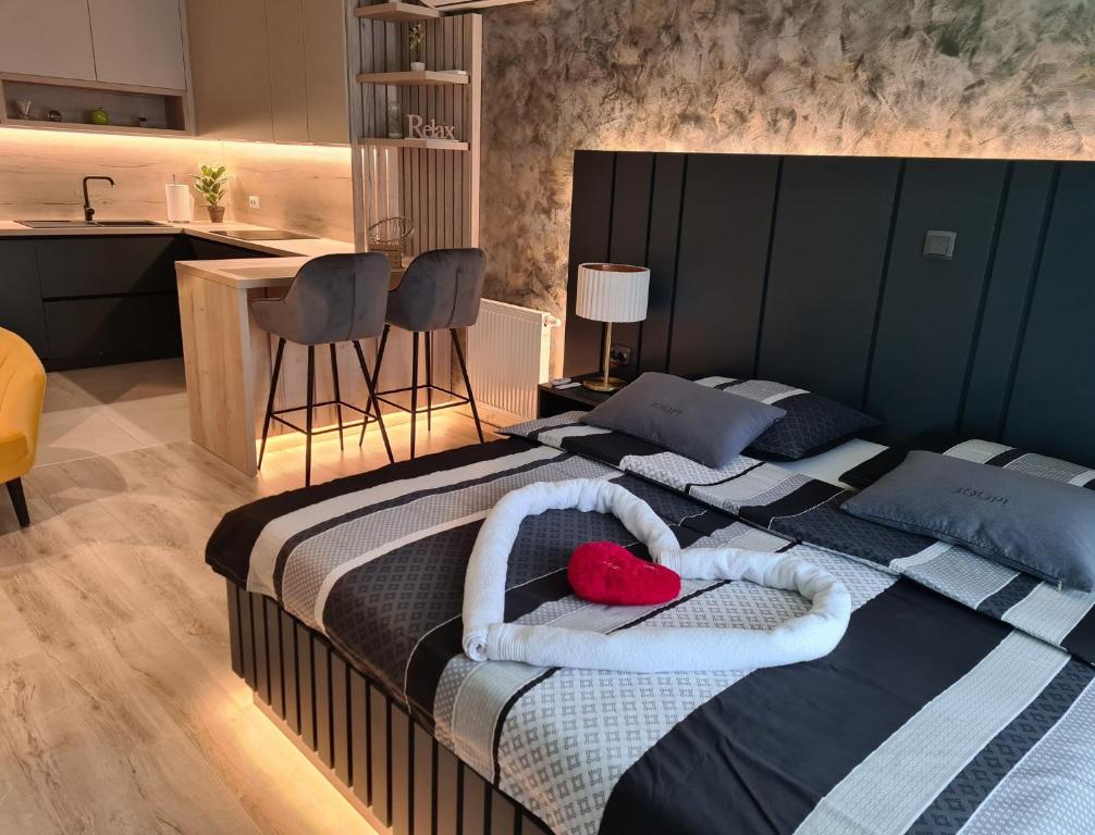 a bedroom with two beds with towels and a kitchen at Wellness Apartments in Varaždin