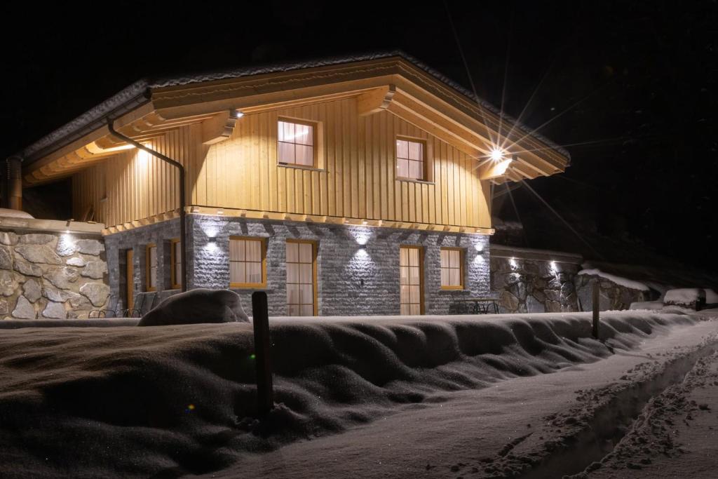 ein Haus mit seitlicher Beleuchtung in der Nacht in der Unterkunft Ferienhaus Bergler Hoamat in Navis