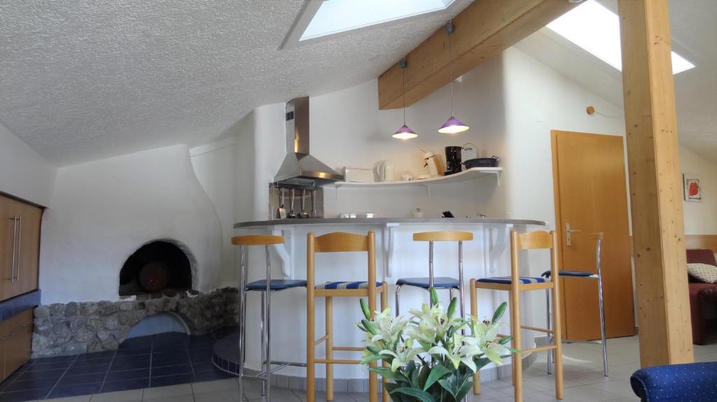 eine Küche mit einer Bar mit Hockern und einem Kamin in der Unterkunft Oberstdorfer Bergwelt 218 in Oberstdorf