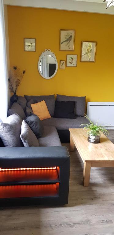 ein Wohnzimmer mit Sofa und Tisch in der Unterkunft La petite maison in Le Bosc-Roger-en-Roumois