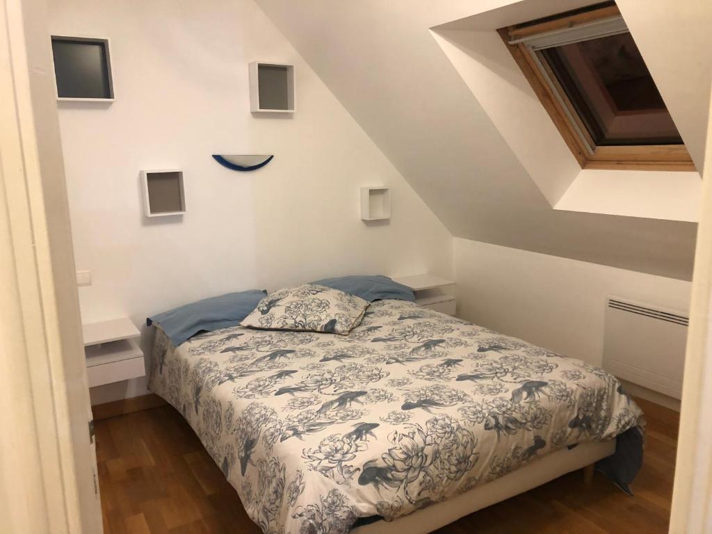 a bedroom with a bed with a blue and white comforter at Maison 4 chambres in Carnac