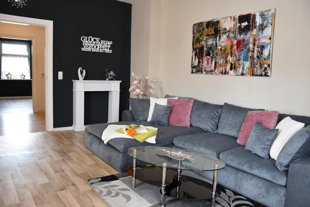 ein Wohnzimmer mit einer grauen Couch und einem Tisch in der Unterkunft Ferienwohnung Wolf in Havelberg