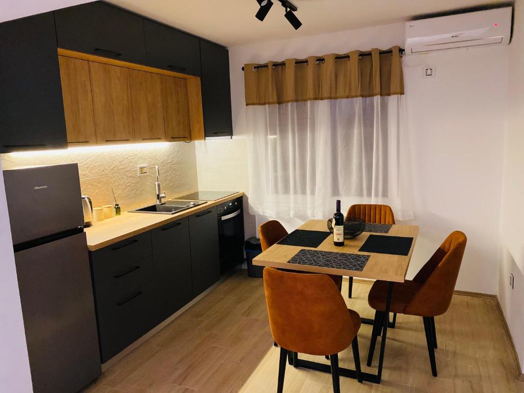 a kitchen with a table and chairs in a kitchen at OM Apartment in Podgorica