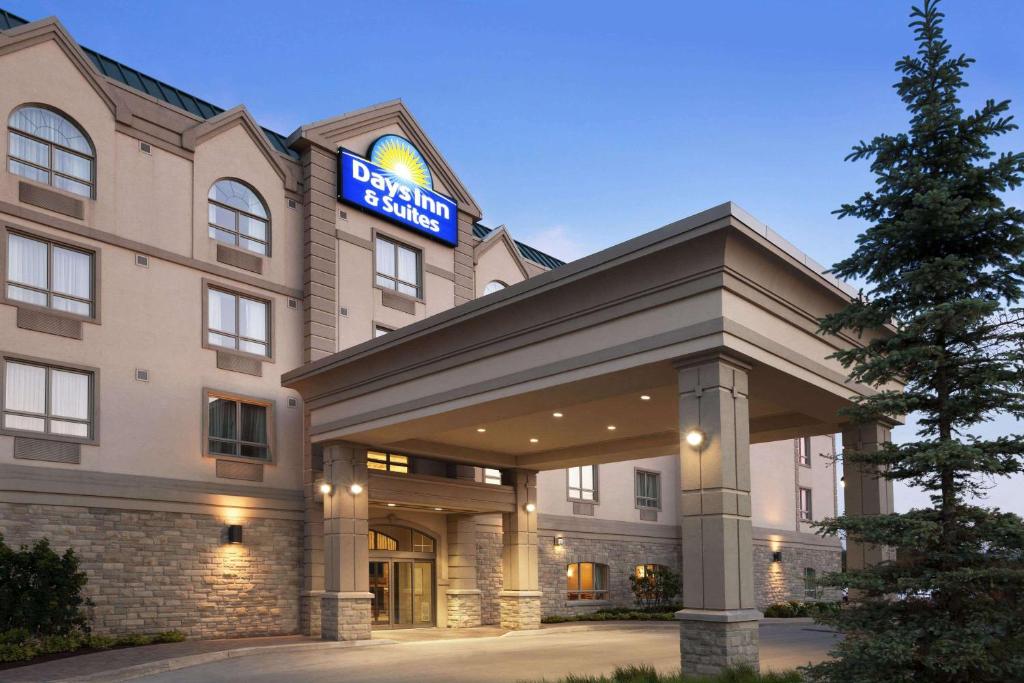 un hotel con un cartel en la parte delantera en Days Inn & Suites by Wyndham Collingwood en Collingwood