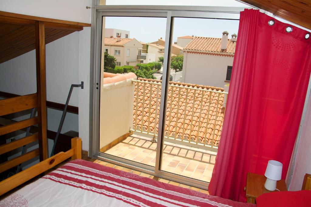 a bedroom with a window with a red curtain at Studio avec vue sur la mer et balcon amenage a Le Barcares in Le Barcarès