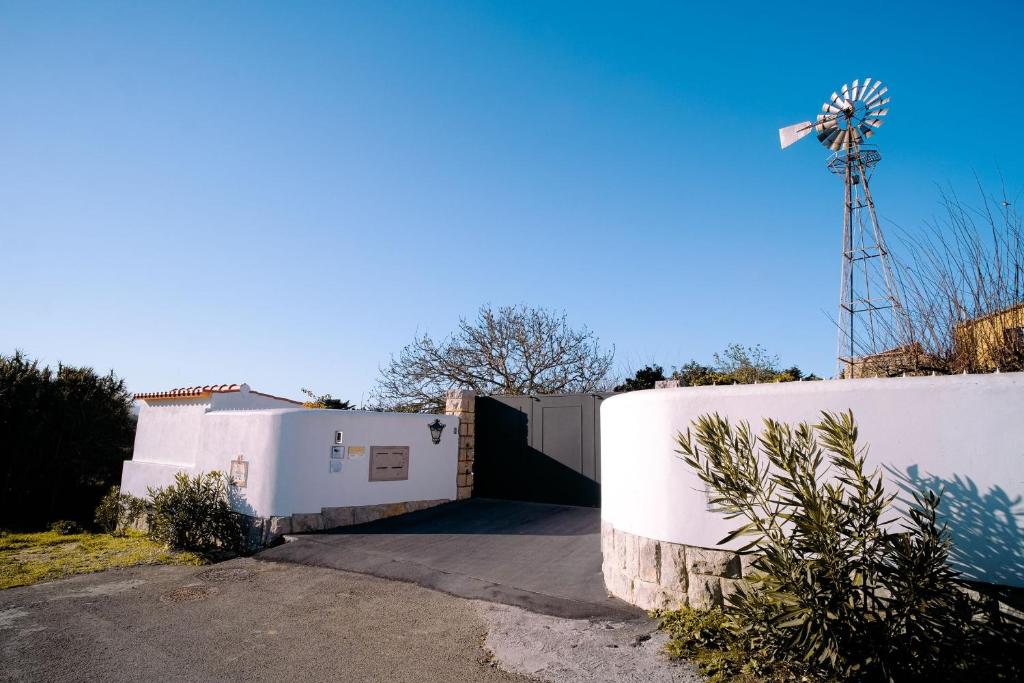 a white house with a fence and a windmill at Kochab Sintra by LovelyStay in Sintra