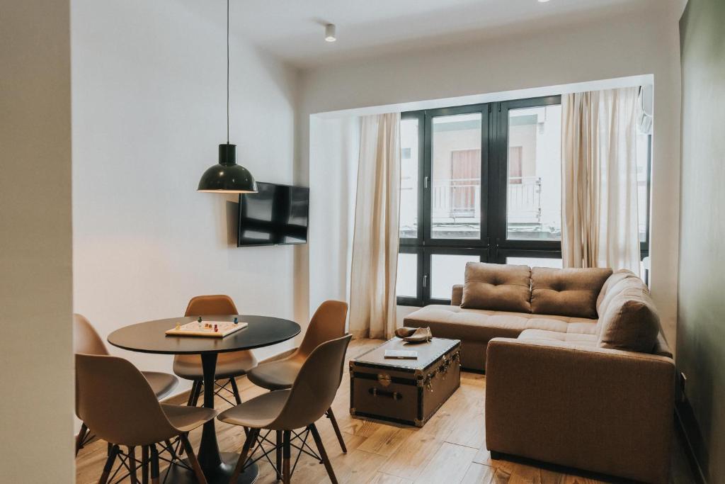 - un salon avec un canapé, une table et des chaises dans l'établissement Contemporary Industrial Apartment by REMS, à Malaga