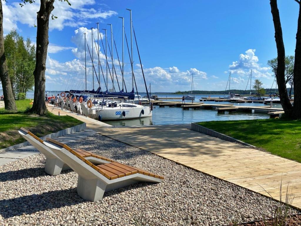 a bench sitting next to a marina with boats at Nautica Resort by Q4Apartments in Giżycko