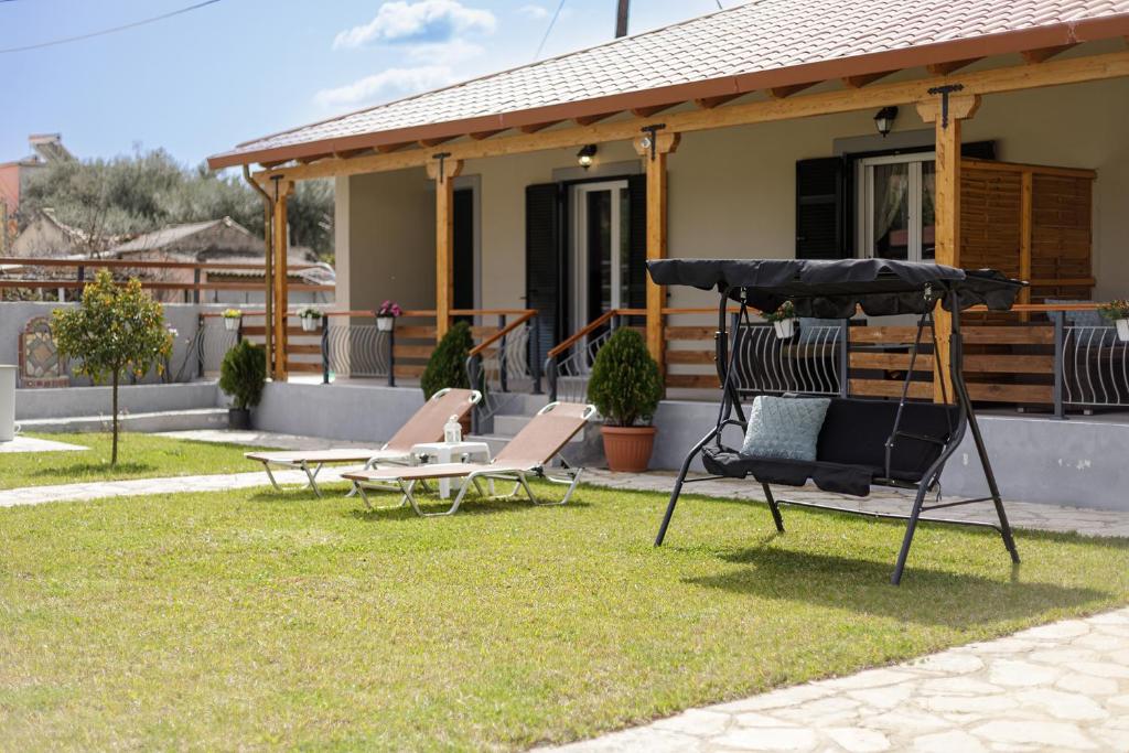 duas cadeiras e um baloiço em frente a uma casa em Planet Villas by Konnect - Shared BBQ & Garden em Ýpsos