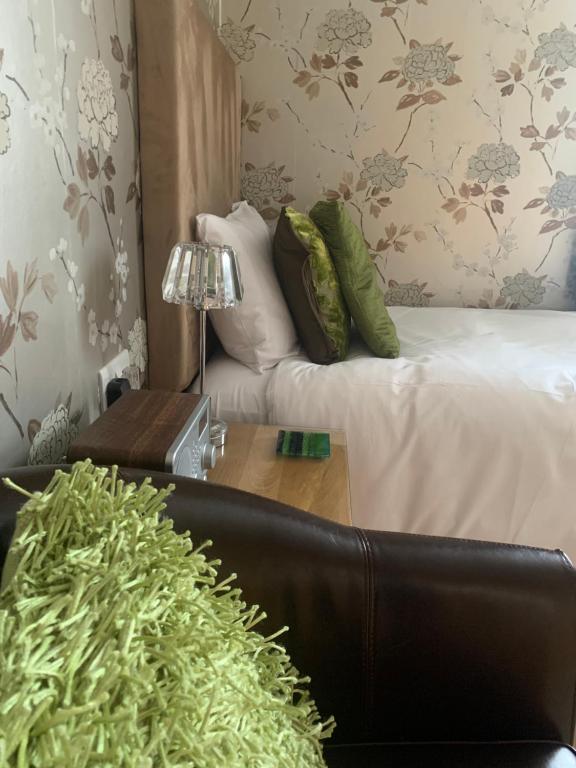 a room with a bed and a table with a couch at Ramsey House - Luxury Licensed B&B - Parking and Guest Lounge in St. Davids