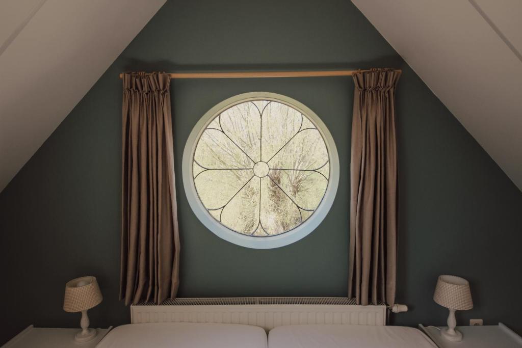 a large clock on a green wall in a bedroom at 't Uilengat 6-8 persoons appartement in Retranchement