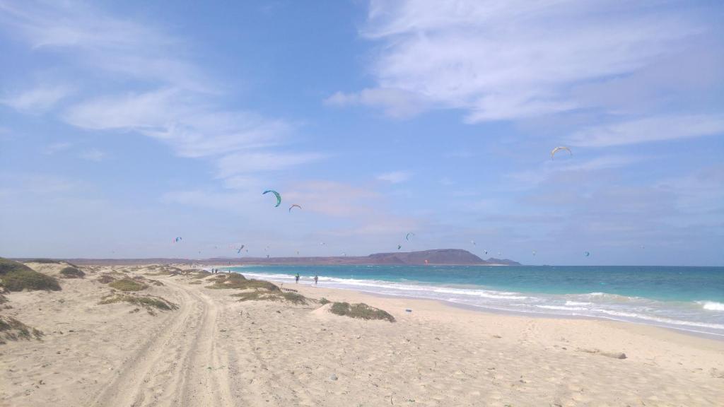 a sandy beach with people flying kites on the ocean at Casa Relaxod in Santa Maria