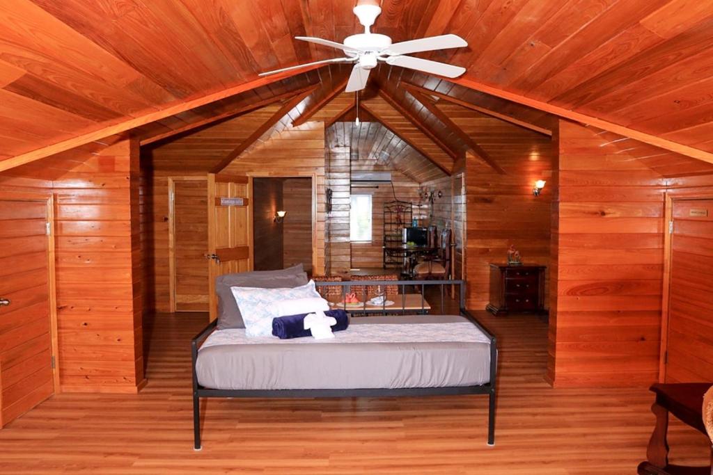 a bedroom with a bed with a ceiling fan at Redknot Manor Guest house/Hotel in Matthew Town