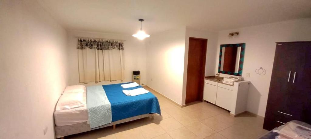 1 dormitorio con 1 cama y TV en Amanecer en Calamuchita en Embalse