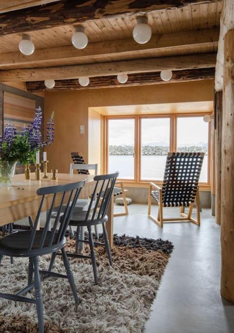 a dining room with chairs and a table and a table and chairsktop at Villa Lofoten - The Saltery in Kvalnes