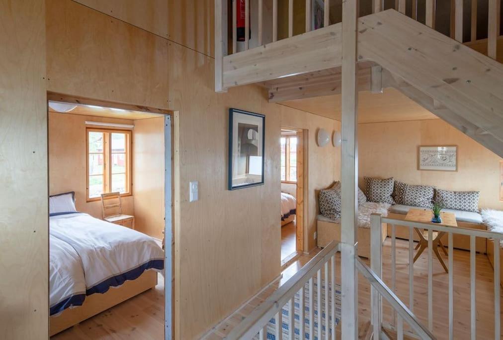 a bedroom with a bed and a staircase in a room at The Saltery in Kvalnes