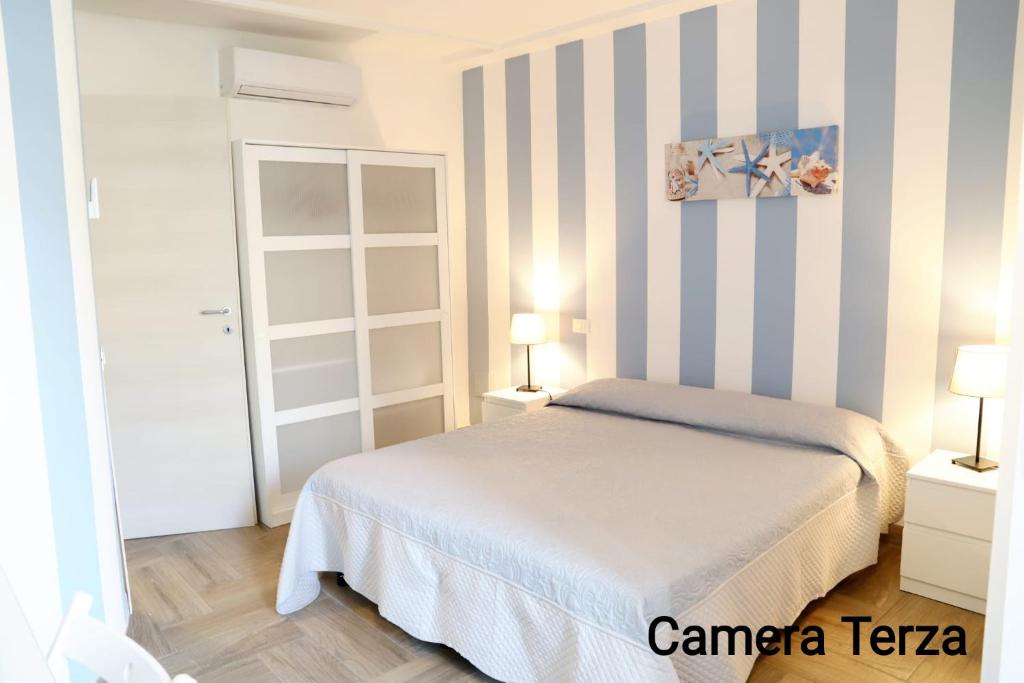 a bedroom with a bed and a striped wall at Casa Piano Ponente in Isola delle Femmine