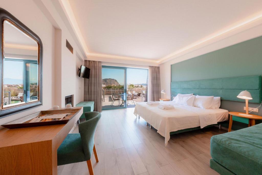 a hotel room with a bed and a desk and a room at Palacio del Sol Luxury Apartments in Nafplio